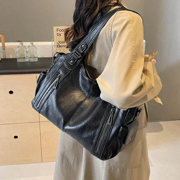 Person wearing a black leather backpack indoors