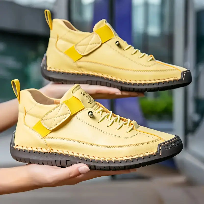 Yellow high-top sneakers held by a person with a blurred background