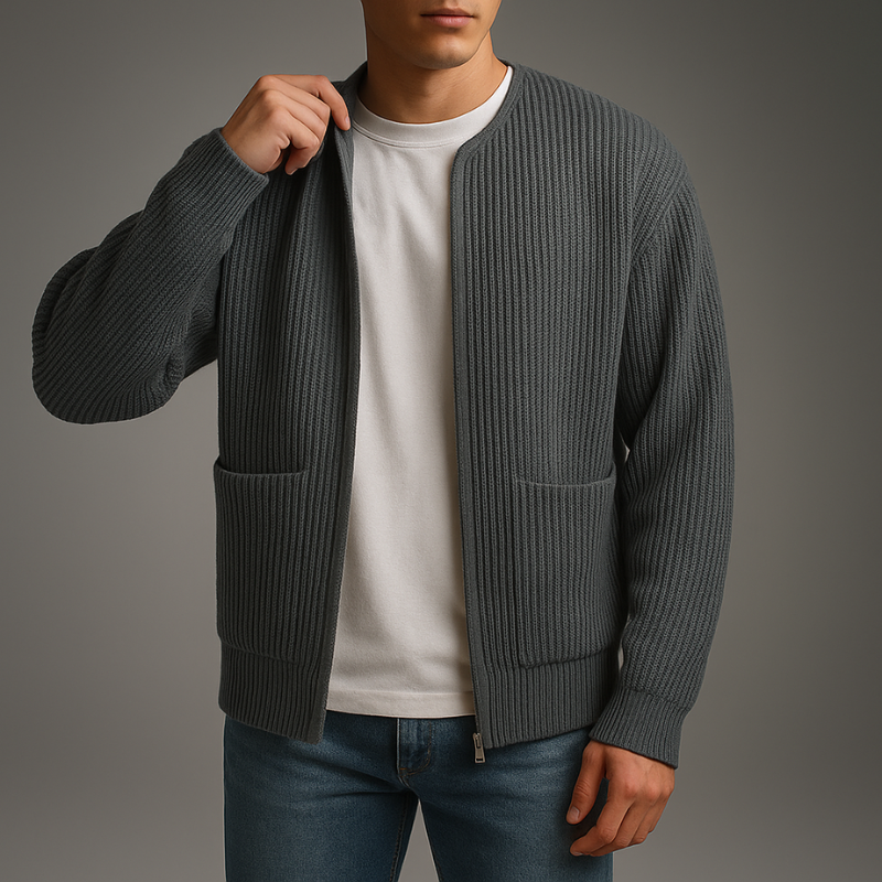 Person wearing a gray cardigan over a white shirt with a gray background