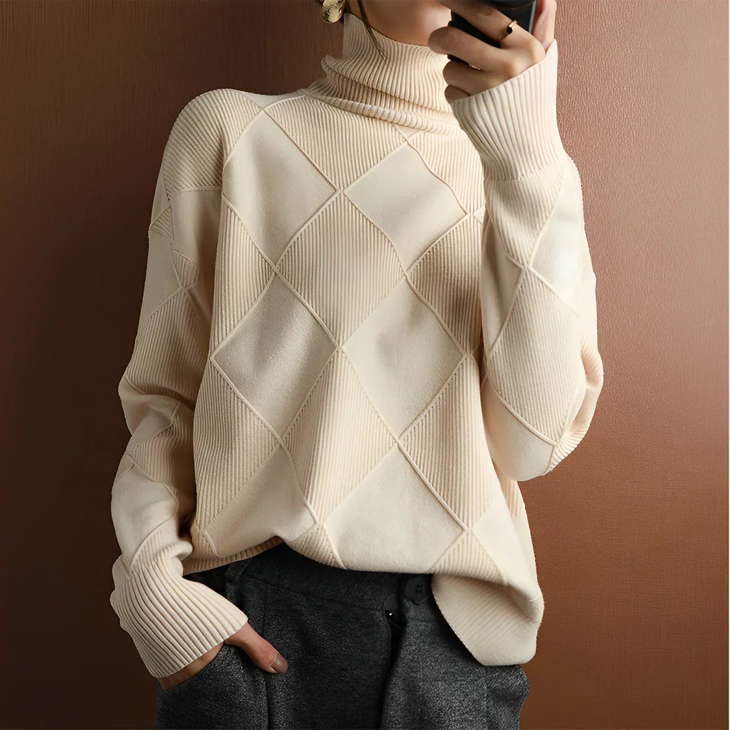 Person wearing an beige turtleneck sweater with dark pants