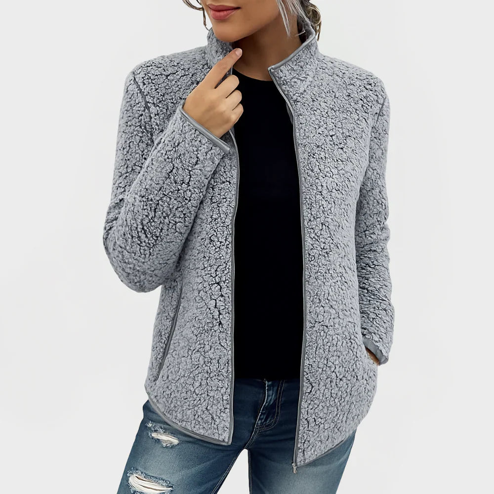 Person wearing a gray fleece jacket on a white background