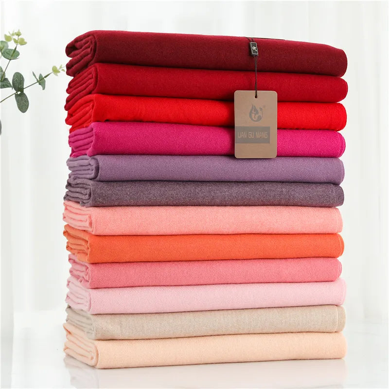 Stack of folded cloths in various colors with a brand tag on a white background