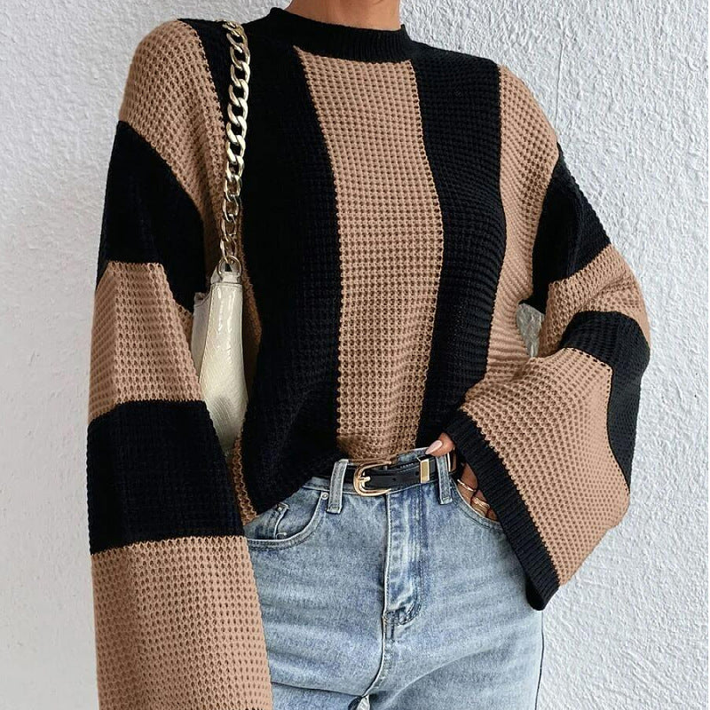 Person wearing a black and beige sweater with a white background
