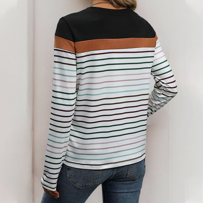 Person wearing a black, brown, and multicolor striped long-sleeve shirt against a white background