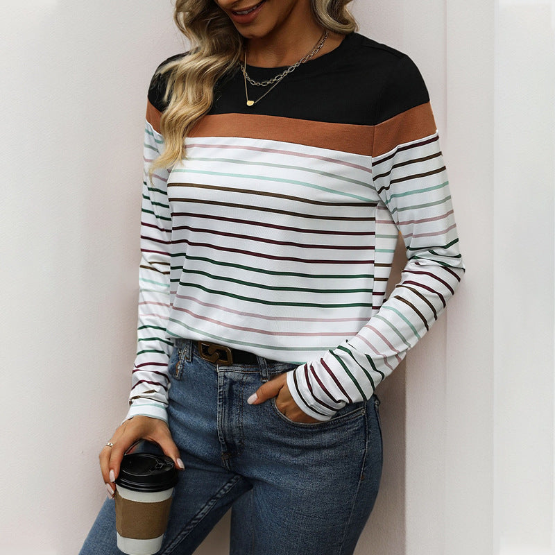 Person wearing a black and white striped long-sleeve top with a brown accent, holding a coffee cup.