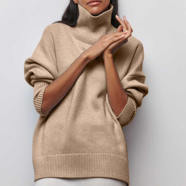 Beige turtleneck sweater worn by a person on a light gray background