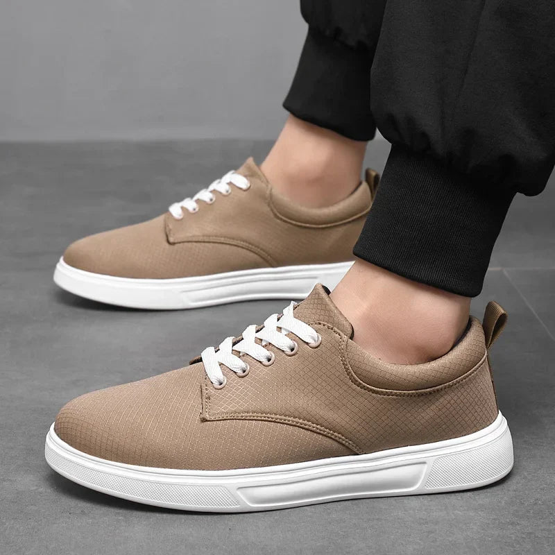 Brown sneakers with white soles worn by a person on a gray background