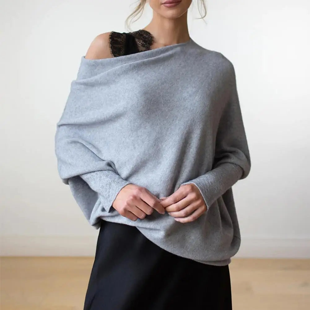 Person wearing a light blue sweater over a black top against a white background