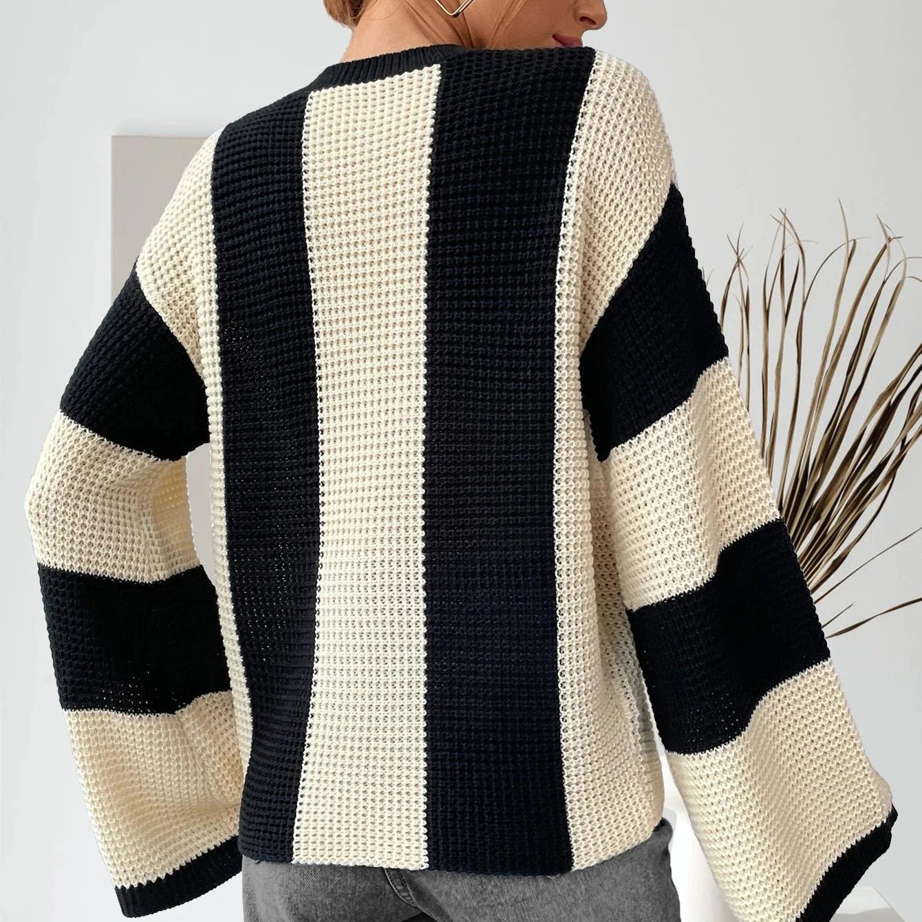 Black and white striped sweater worn by a person, with a neutral background