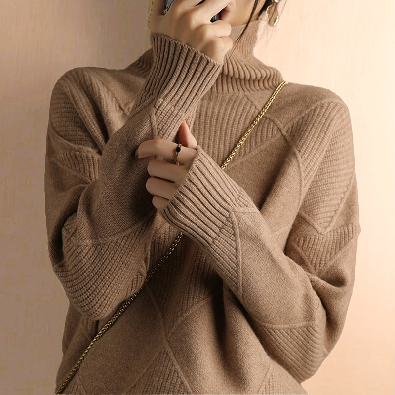 Person wearing a camel turtleneck sweater with dark pants