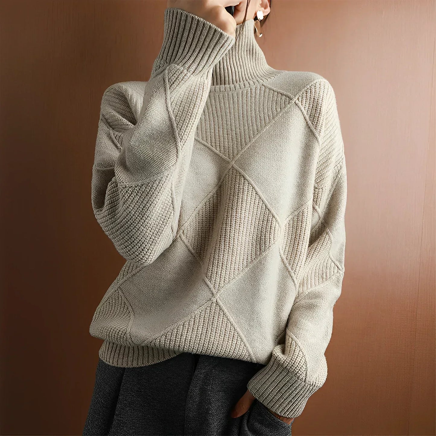 Person wearing a light gray turtleneck sweater with dark pants