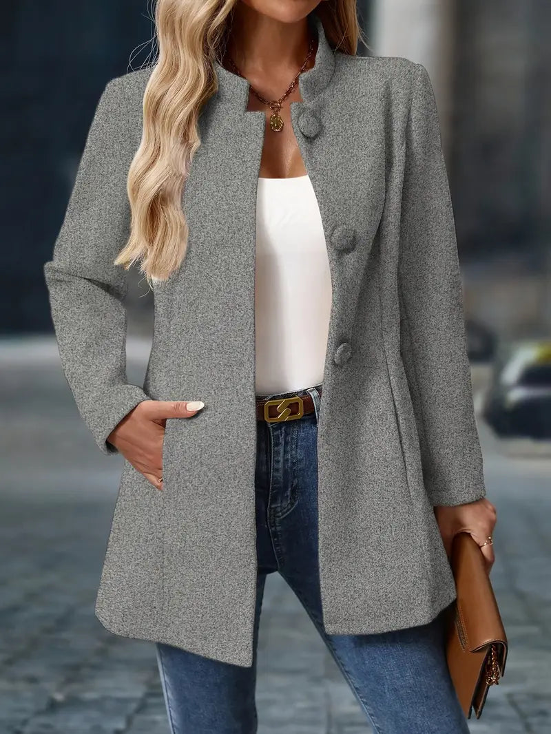 Woman wearing a gray coat with a blurred street background