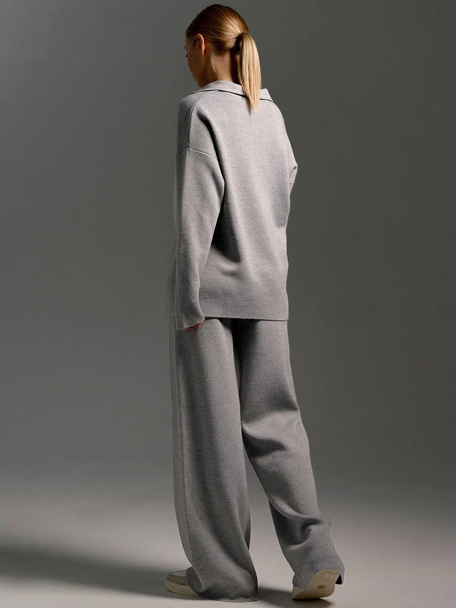 Person wearing a gray tracksuit against a gray background