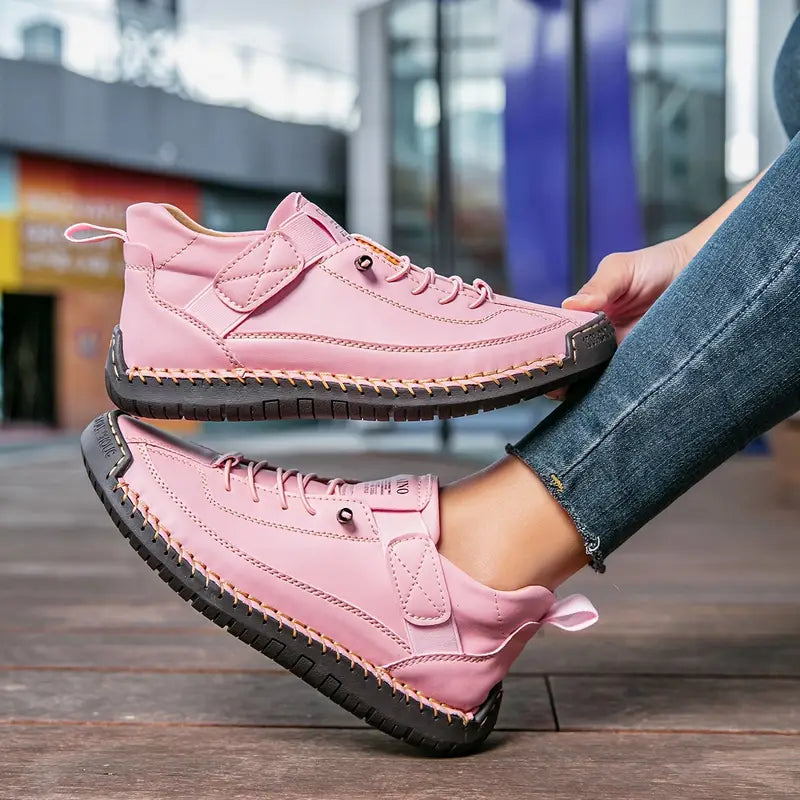 Person wearing pink high-top sneakers with black soles on a blurred urban background