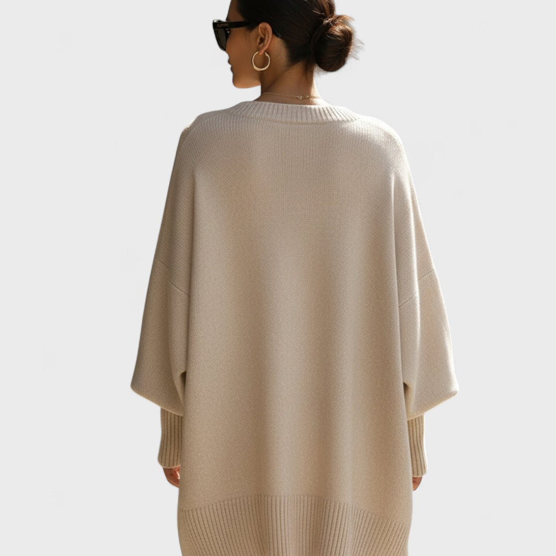 Person wearing a beige sweater with a plain background