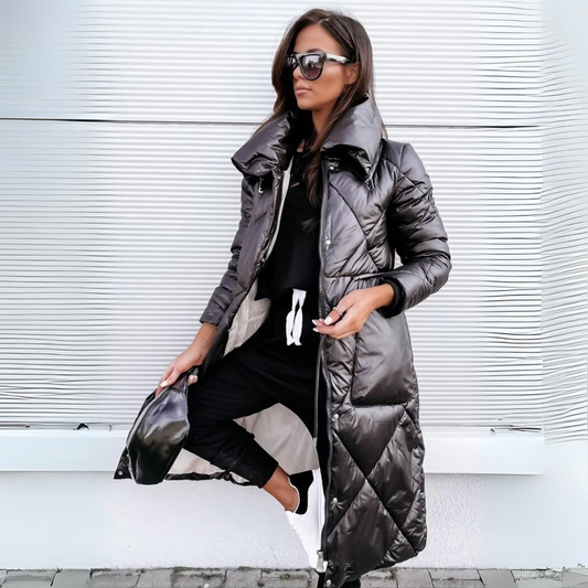 Woman wearing a long black quilted coat against a white background