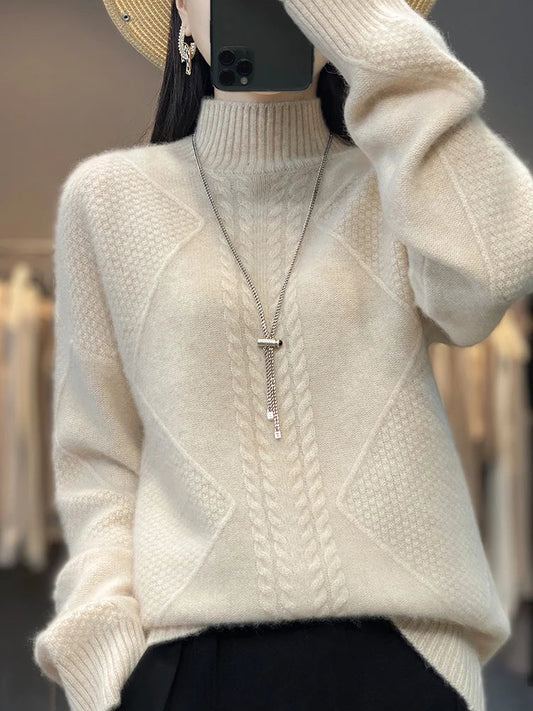 Person wearing a beige cable knit sweater with a blurred background