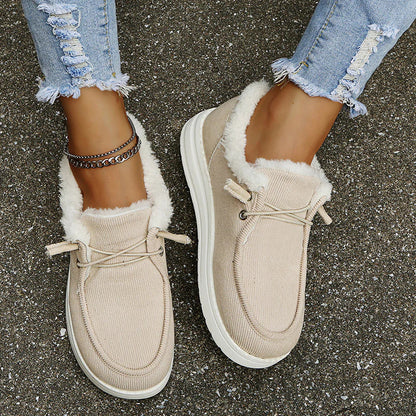 Beige sneakers with white fur lining worn on a concrete surface