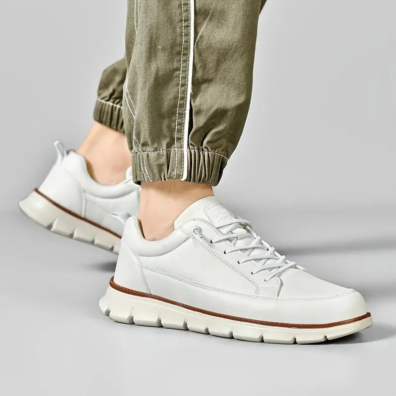 White sneakers with brown accents worn by a person on a gray background