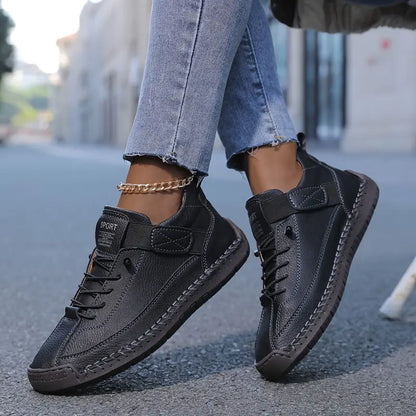 Black sneakers worn with light blue jeans on a blurred street background
