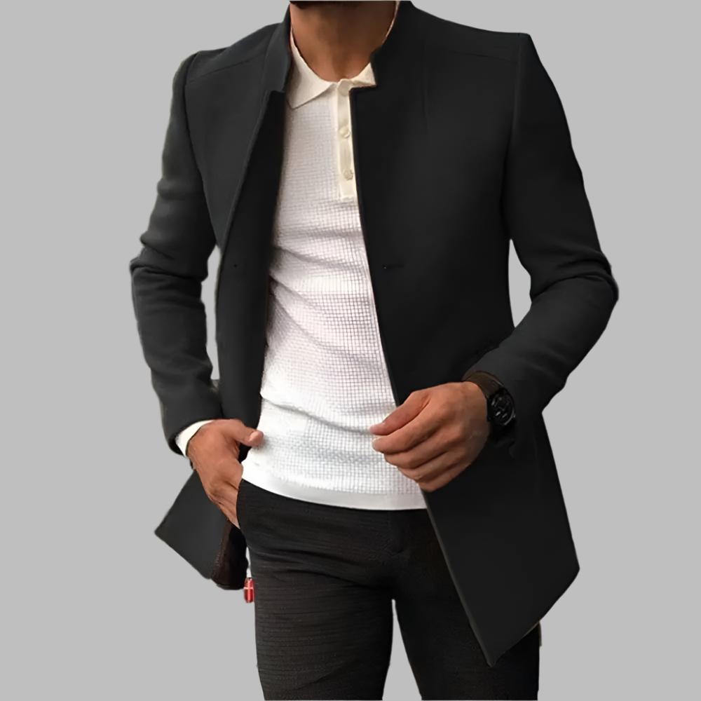 Person wearing a black coat over a white shirt on a gray background