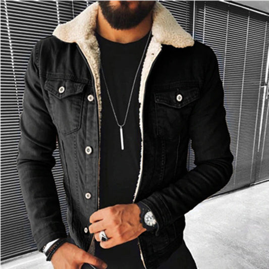 Person wearing a black denim jacket with white fur lining against a metallic background