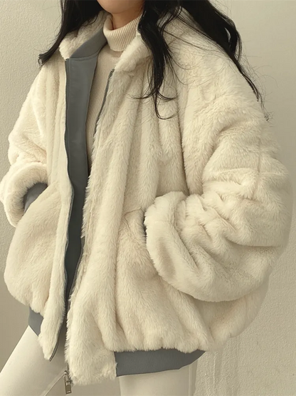 Person wearing a white fur coat against a neutral background