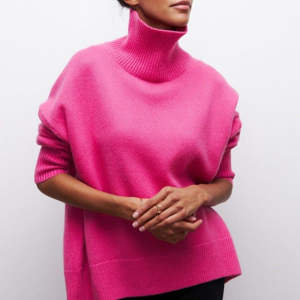 Person wearing a bright pink turtleneck sweater on a plain background