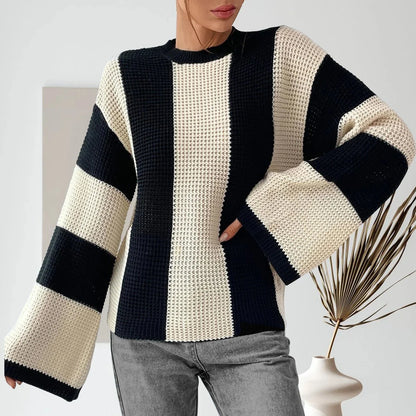 Person wearing a black and white striped sweater with a minimal background