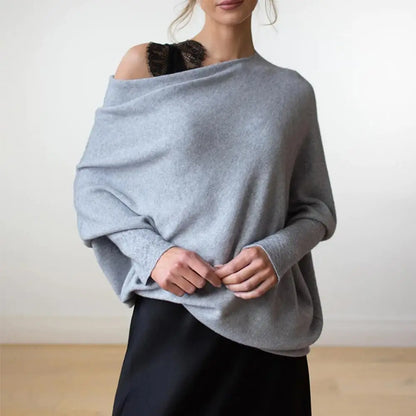 Person wearing a light blue sweater over a black top against a white background