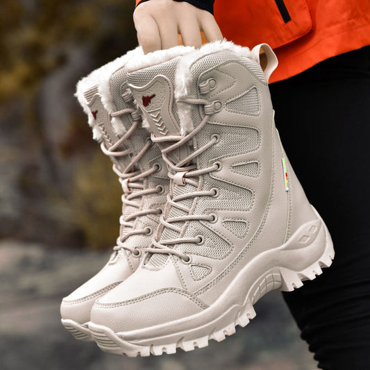 Beige winter boots with fur lining held by a person wearing an orange jacket.