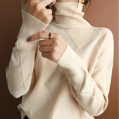 Person wearing a beige turtleneck sweater with dark pants
