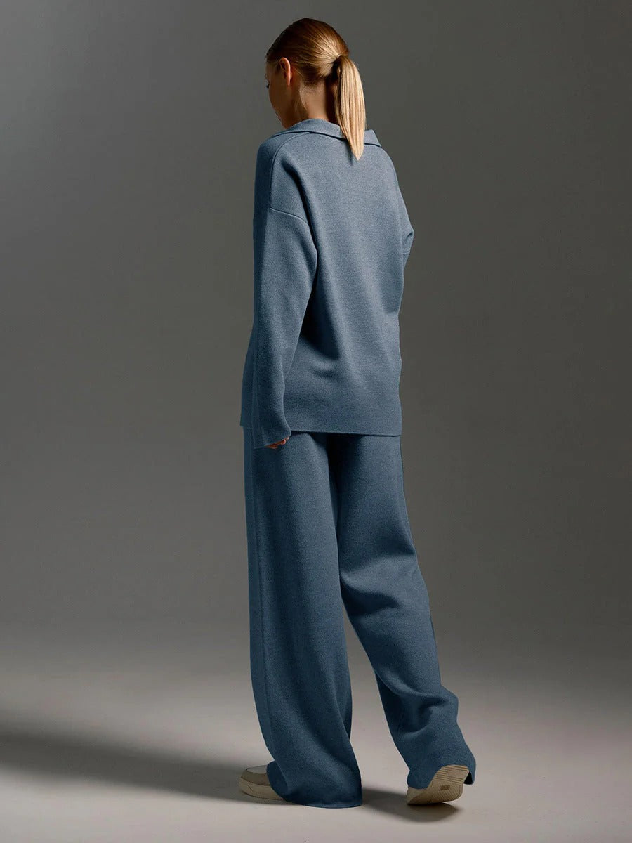 Person wearing a blue outfit standing against a gray background