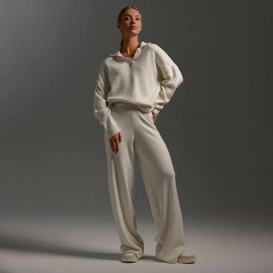 Person wearing a beige tracksuit against a gray background